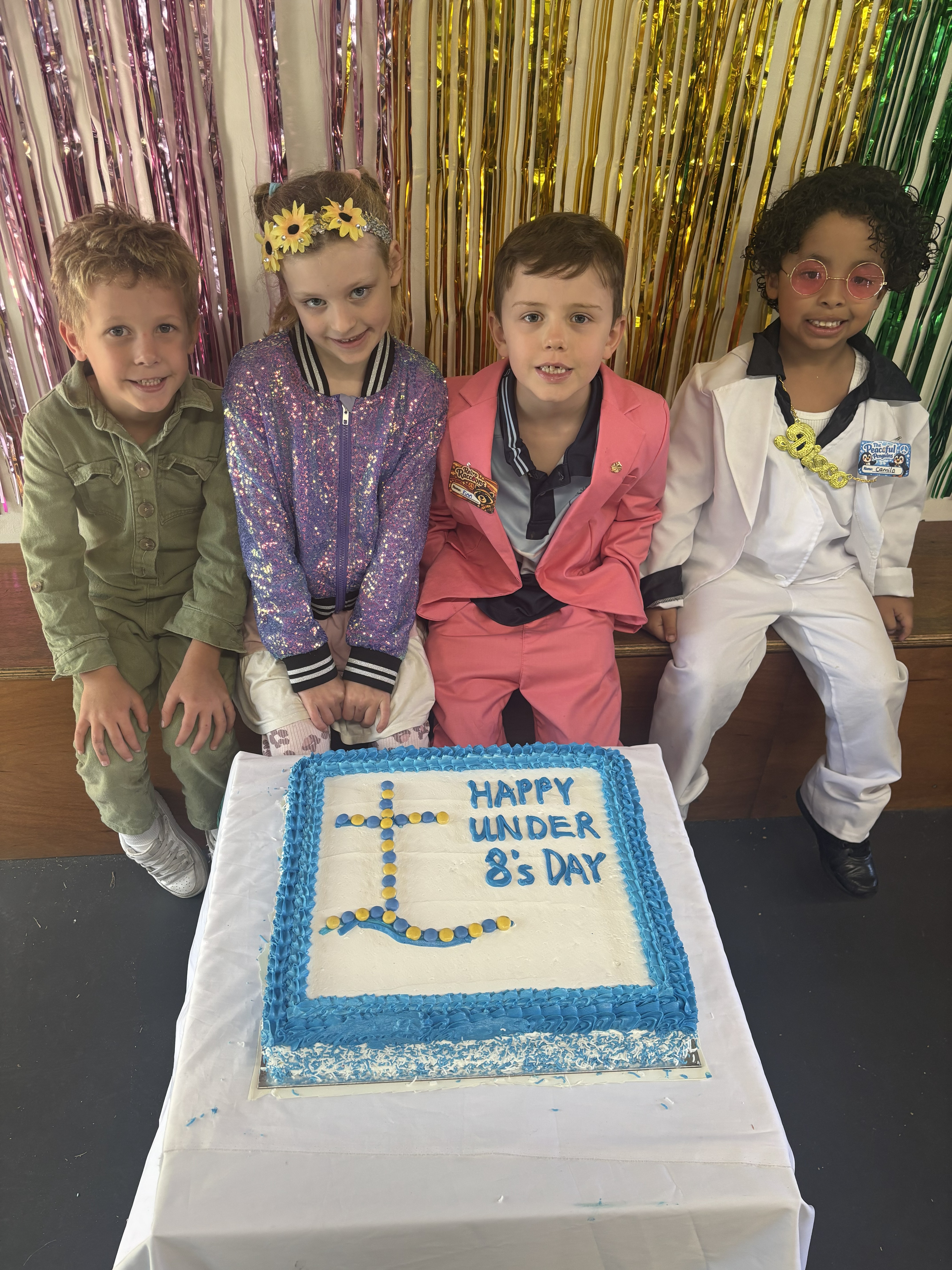 Four students around a cake for 70 years of play